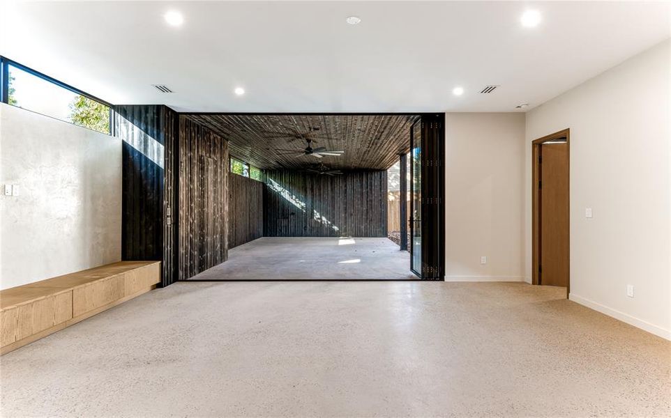 Living room with glass doors open to patio / outdoor living area, prepped for an outdoor kitchen.