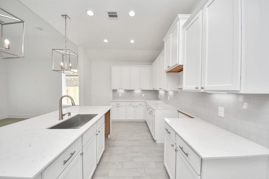 Step into a dream realized with this generously spacious kitchen! A massive granite island takes center stage, complemented by high ceilings and soft-close cabinets. The granite countertops, stainless steel appliances, sleek tile backsplash, and recessed lighting complete the elegant design. Step into a dream realized with this generously spacious kitchen! A massive granite island takes center stage, complemented by high ceilings and soft-close cabinets. The granite countertops, stainless steel appliances, sleek tile backsplash, and recessed lighting complete the elegant design.