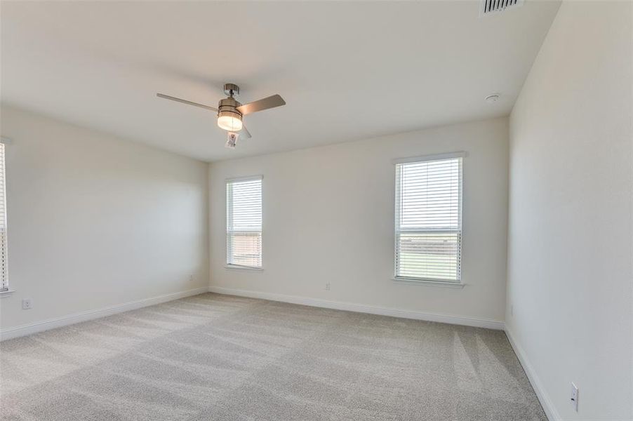 Unfurnished room featuring light carpet and a ceiling fan