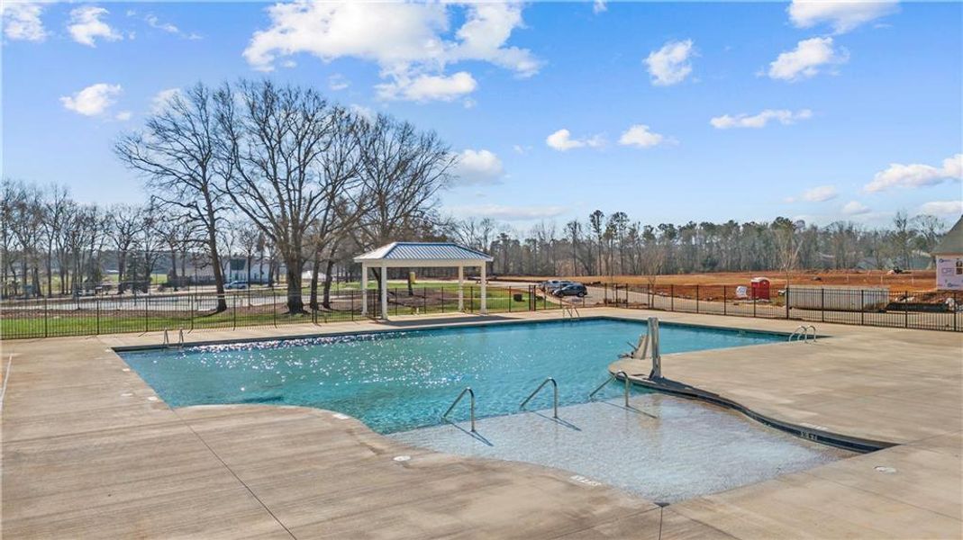 An inviting outdoor pool with a shaded gazebo awai
