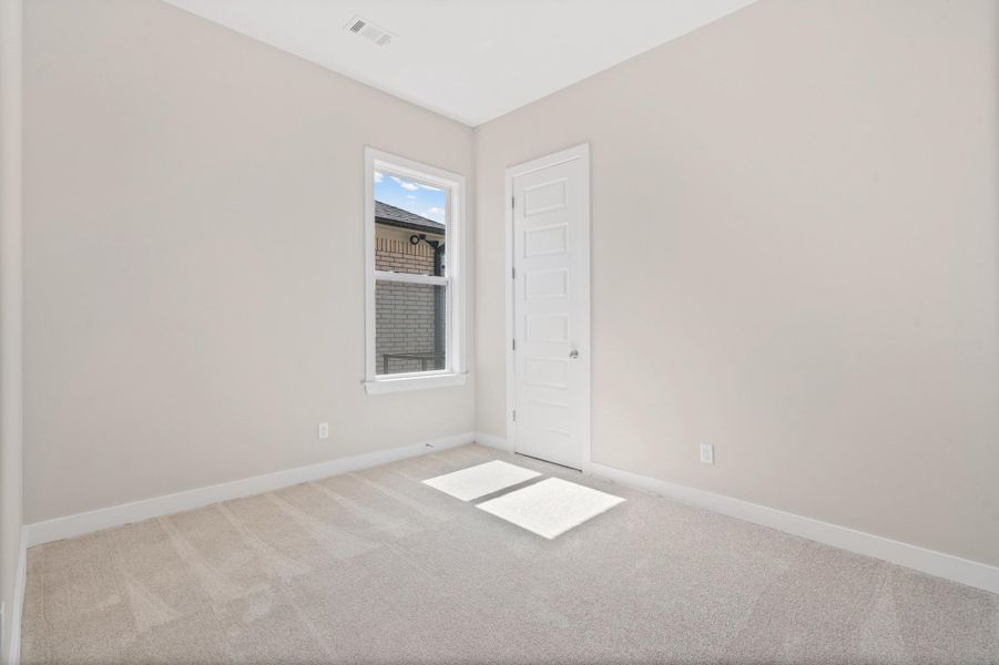 Spare room with light carpet and baseboards