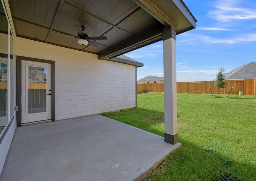 Covered rear patio featuring a ceiling fan and a view of the fenced backyard.