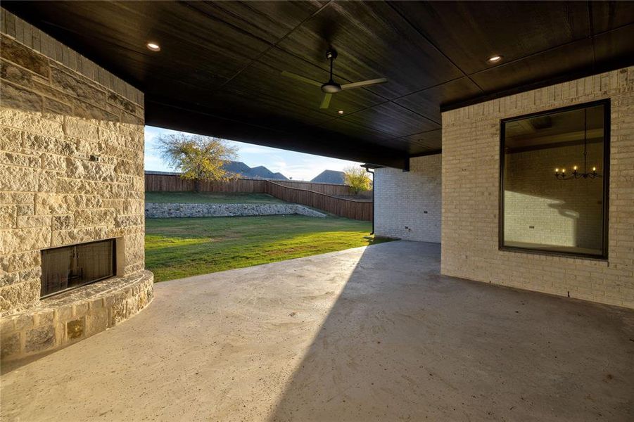 View of patio / terrace with an outdoor stone fireplace, ceiling fan, and a mountain view