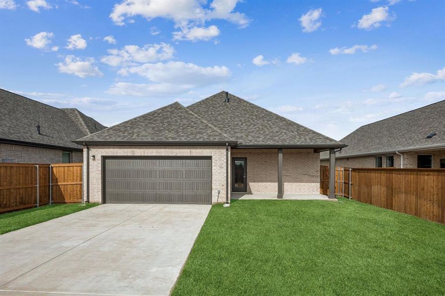 Rear view of house with brick siding, a shingled roof, a patio area, concrete driveway, and a garage Rear view of house with brick siding, a shingled roof, a patio area, concrete driveway, and a garage