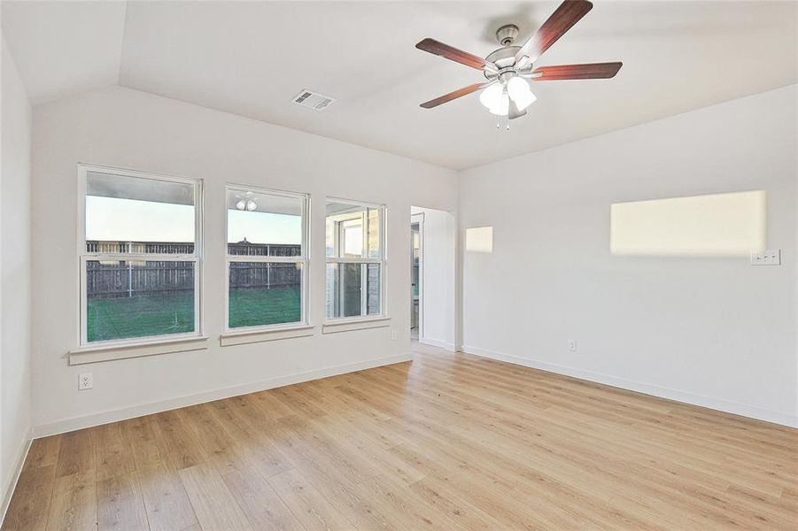 Spare room with light hardwood / wood-style floors, ceiling fan, and vaulted ceiling