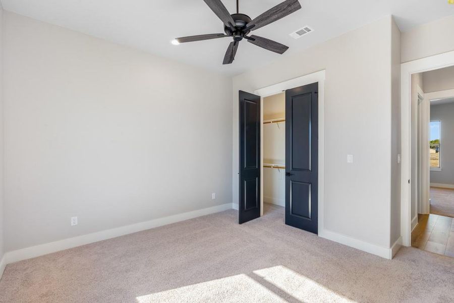 Unfurnished bedroom featuring a closet, ceiling fan, and light colored carpet