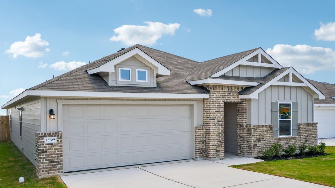 Front exterior of a new home in Carillon, Manor, TX, highlighting curb appeal (Image 2).