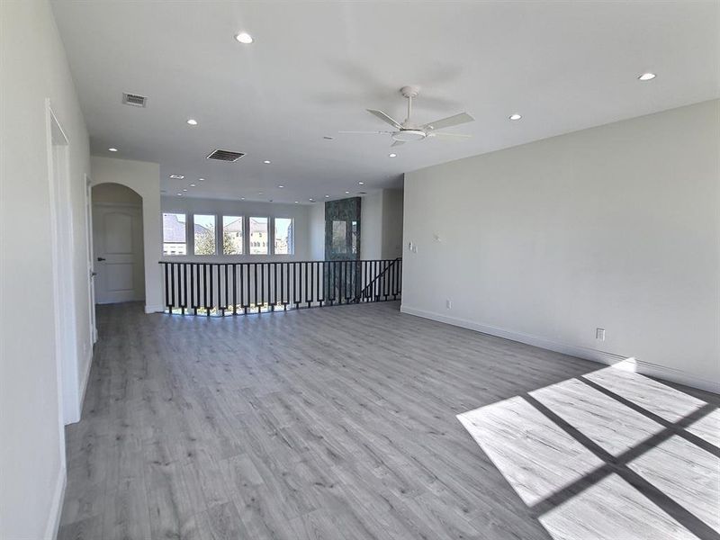 Empty room featuring ceiling fan and light hardwood / wood-style flooring