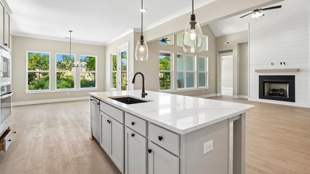 Hanging lights over elevated kitchen island with sink and dishwasher Hanging lights over elevated kitchen island with sink and dishwasher