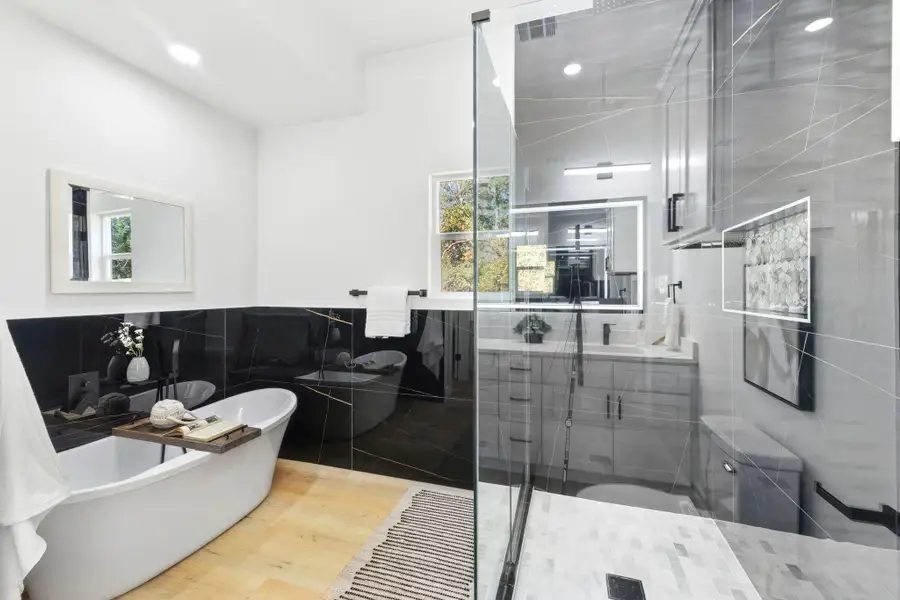 Full bathroom with a freestanding bath, tile walls, a stall shower, vanity, and plenty of natural light Full bathroom with a freestanding bath, tile walls, a stall shower, vanity, and plenty of natural light