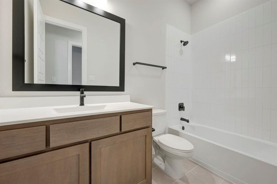 Full bathroom featuring vanity, shower / bath combination, and light tile patterned floors