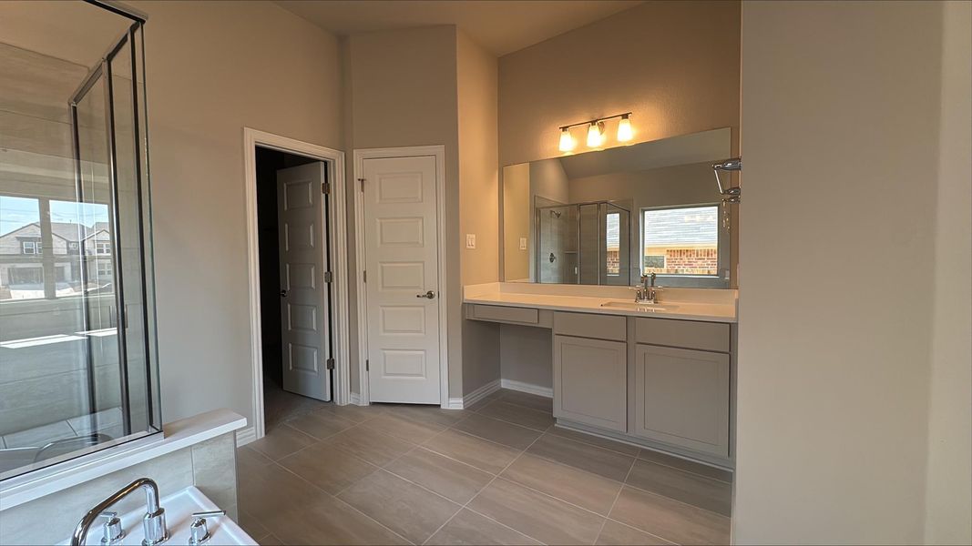 Bathroom featuring vanity, a stall shower, and light tile patterned flooring