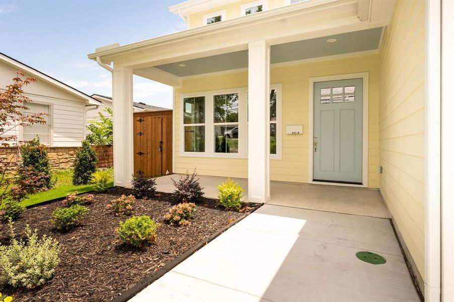 Covered front porch with a light blue ceiling, yellow siding, and a light blue paneled door with upper glass inserts Covered front porch with a light blue ceiling, yellow siding, and a light blue paneled door with upper glass inserts