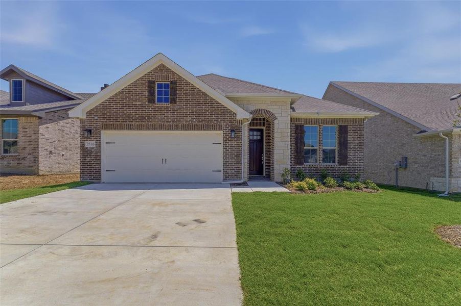 Brick and stone exterior featuring an arched entryway and dark wood front door Brick and stone exterior featuring an arched entryway and dark wood front door