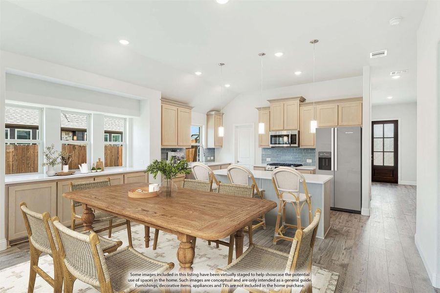 Open dining area with wood table flowing into kitchen with light wood cabinets and stainless appliances Open dining area with wood table flowing into kitchen with light wood cabinets and stainless appliances