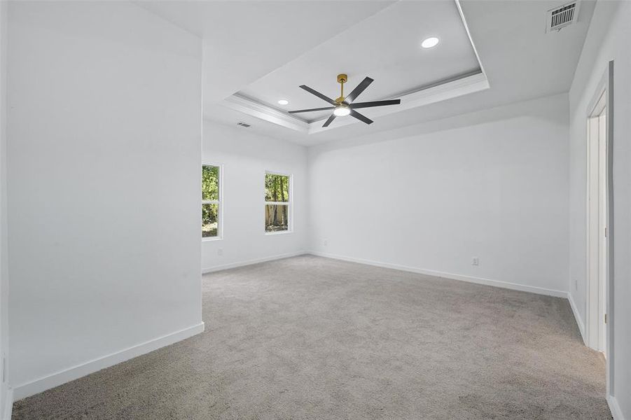 Spare room featuring a raised ceiling, light colored carpet, recessed lighting, and a ceiling fan Spare room featuring a raised ceiling, light colored carpet, recessed lighting, and a ceiling fan