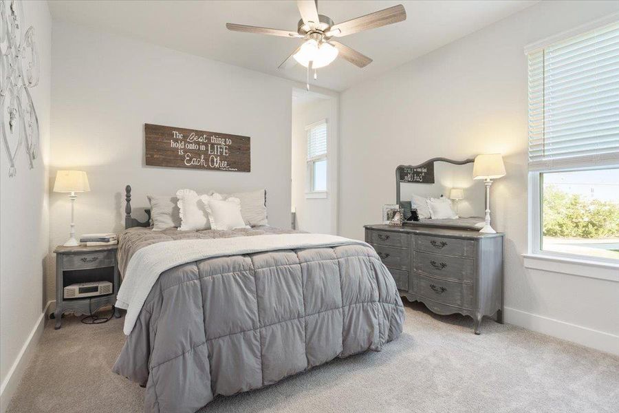 Carpeted bedroom with baseboards and a ceiling fan