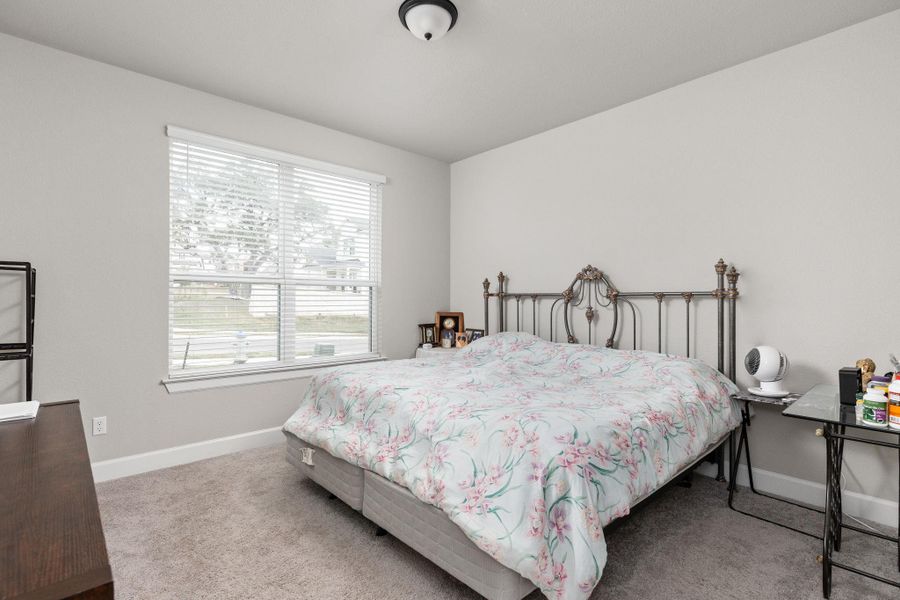 Bedroom featuring light colored carpet and baseboards