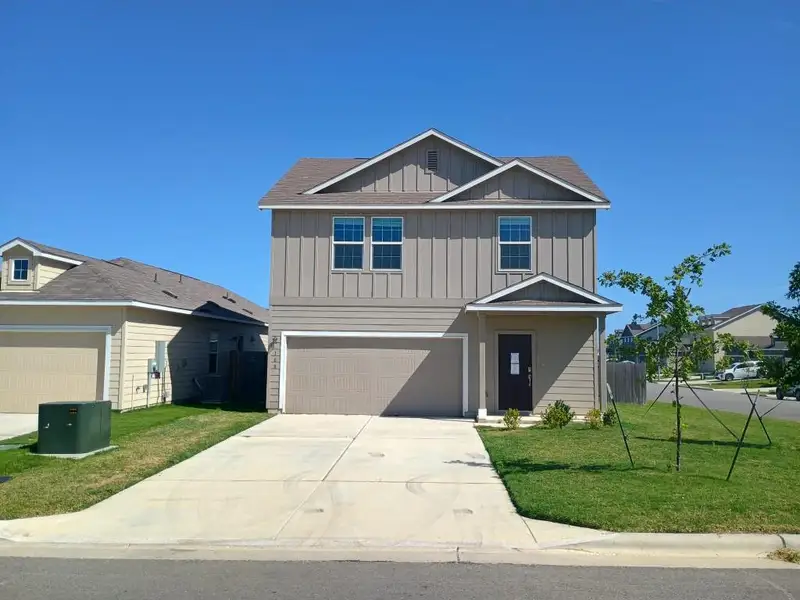 View of front of home featuring board and batten siding, an attached garage, and driveway View of front of home featuring board and batten siding, an attached garage, and driveway