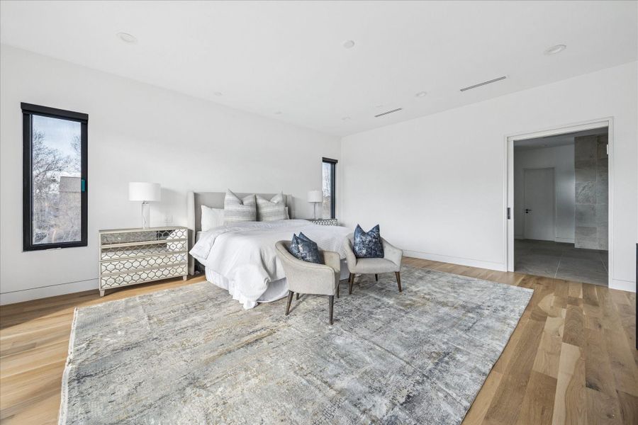 The spacious primary suite greets you with tall ceilings and natural light.