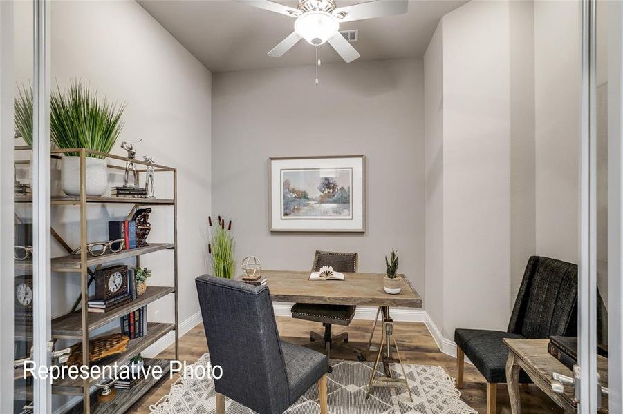 This versatile room features light-toned walls, a ceiling fan, and wood-look flooring