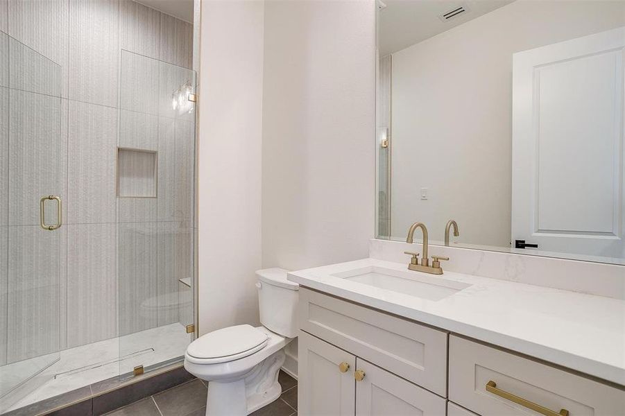 Full bath with vanity, visible vents, a tile shower, tile patterned floors, and toilet