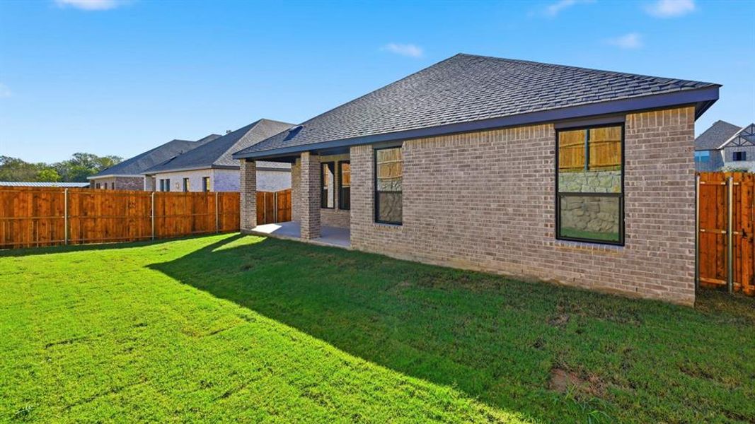 Back of house featuring brick siding, a patio area, a fenced backyard, and a shingled roof Back of house featuring brick siding, a patio area, a fenced backyard, and a shingled roof