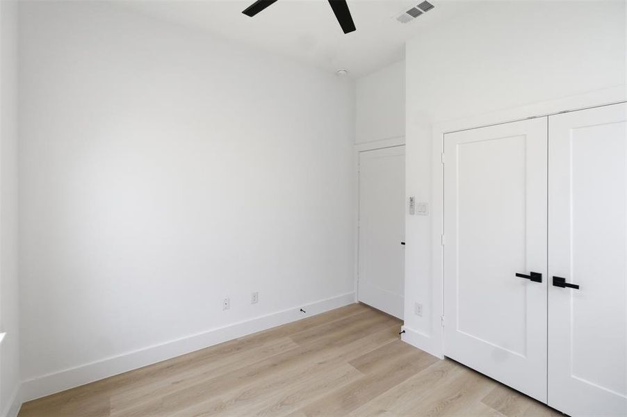 Unfurnished bedroom featuring light wood-style floors, a ceiling fan, and a closet