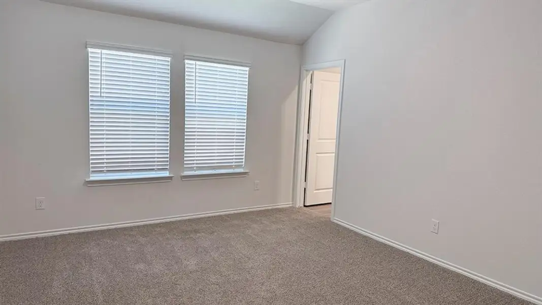 Empty room with carpet flooring and lofted ceiling