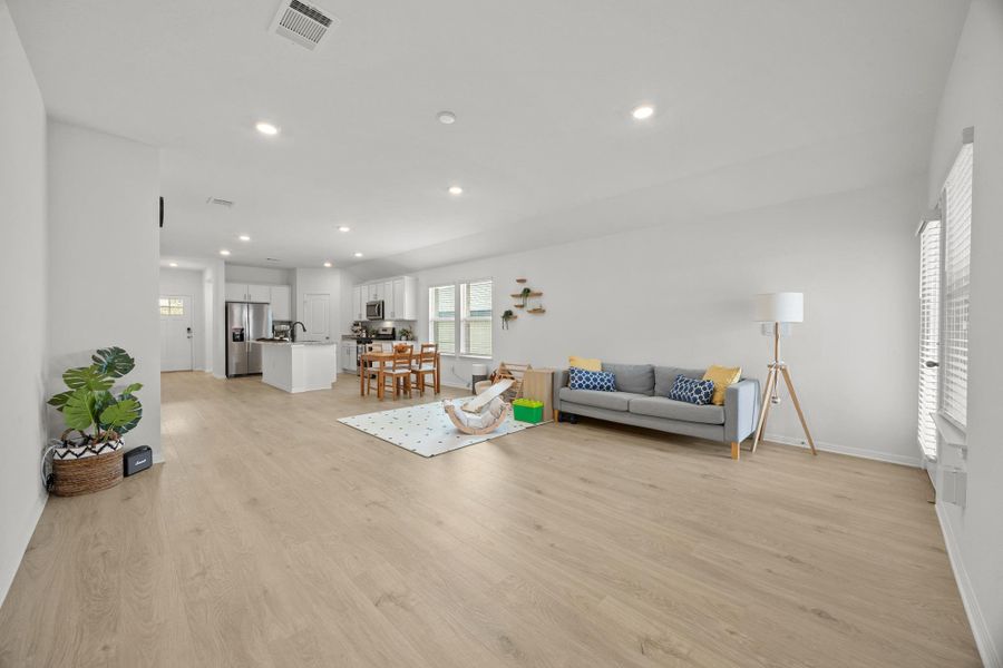 Living area featuring light wood finished floors and recessed lighting