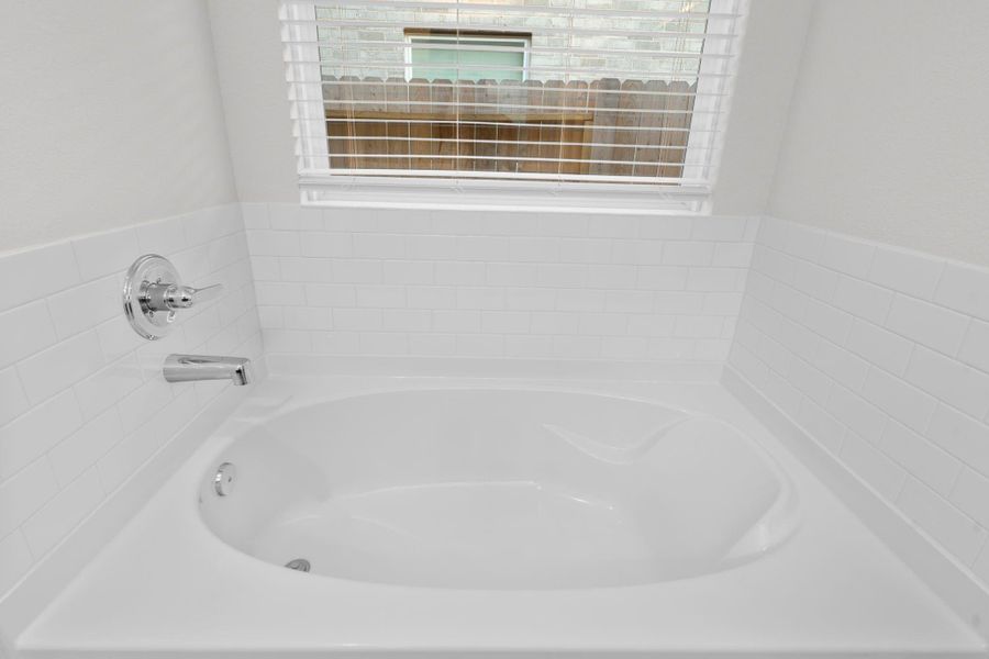 The primary bathroom features a deep soaking tub positioned beneath a large window that fills the space with soft natural light. It offers the perfect place to relax after a long day and enjoy a peaceful retreat right at home. Bubble me away! The primary bathroom features a deep soaking tub positioned beneath a large window that fills the space with soft natural light. It offers the perfect place to relax after a long day and enjoy a peaceful retreat right at home. Bubble me away!