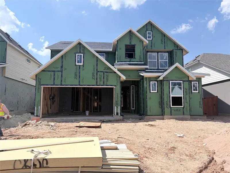 New construction home under development showcases multi-gabled rooflines and a spacious three-car garage framing.