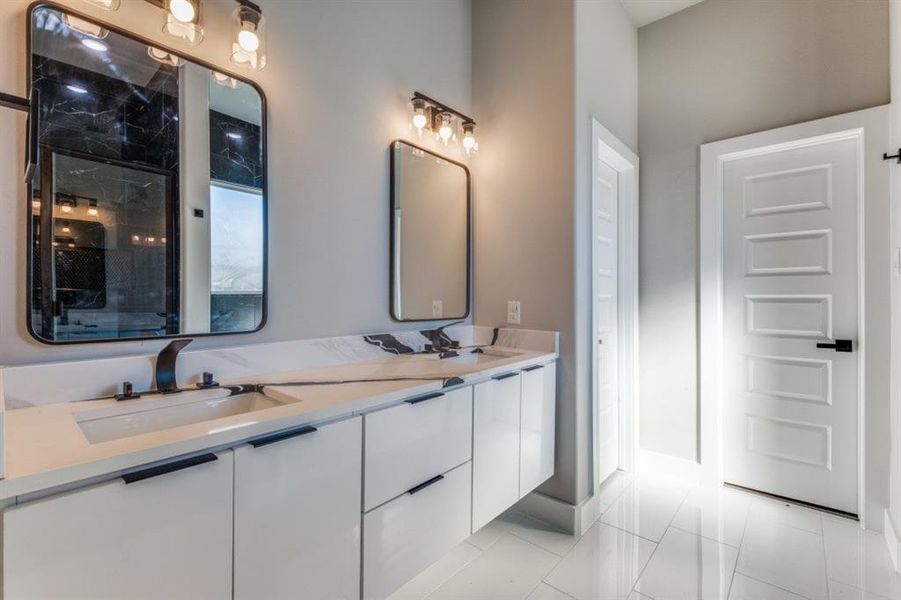 Full bathroom featuring double vanity and a shower with door