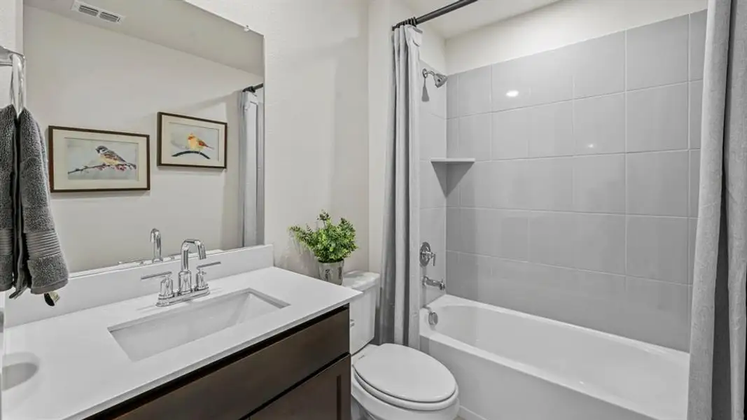 Contemporary bathroom featuring a dark wood-finish vanity with an integrated rectangular sink