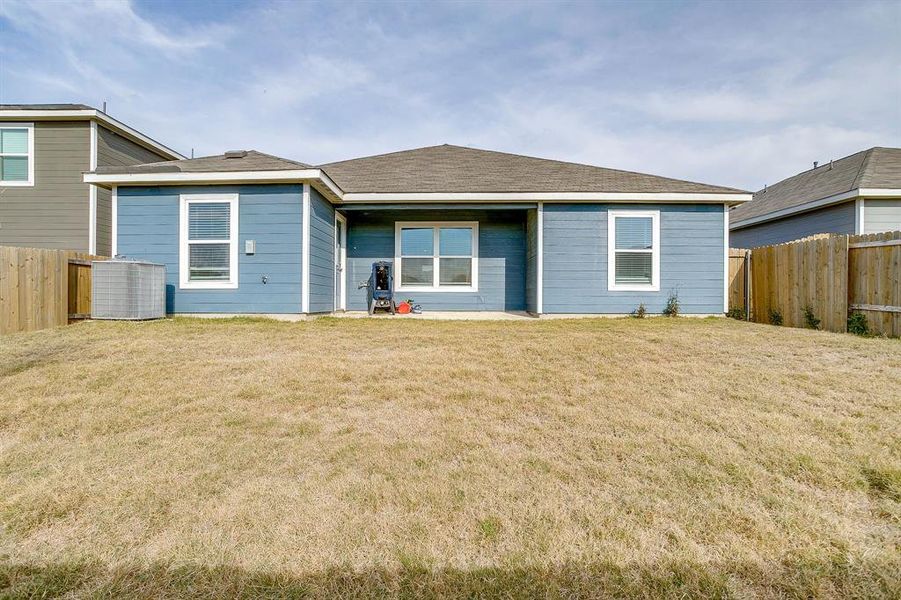 View of front facade with a fenced backyard, a patio area, and roof with shingles