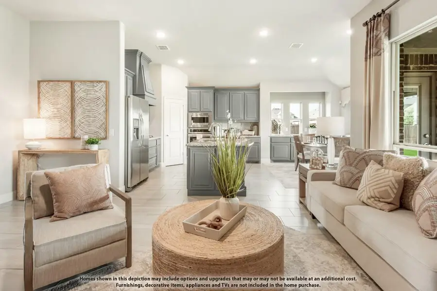 Open-concept living room with tile floors and kitchen featuring gray cabinets and stainless steel appliances visible in background