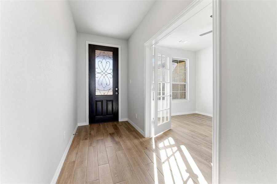Foyer entrance featuring light wood-type flooring and baseboards