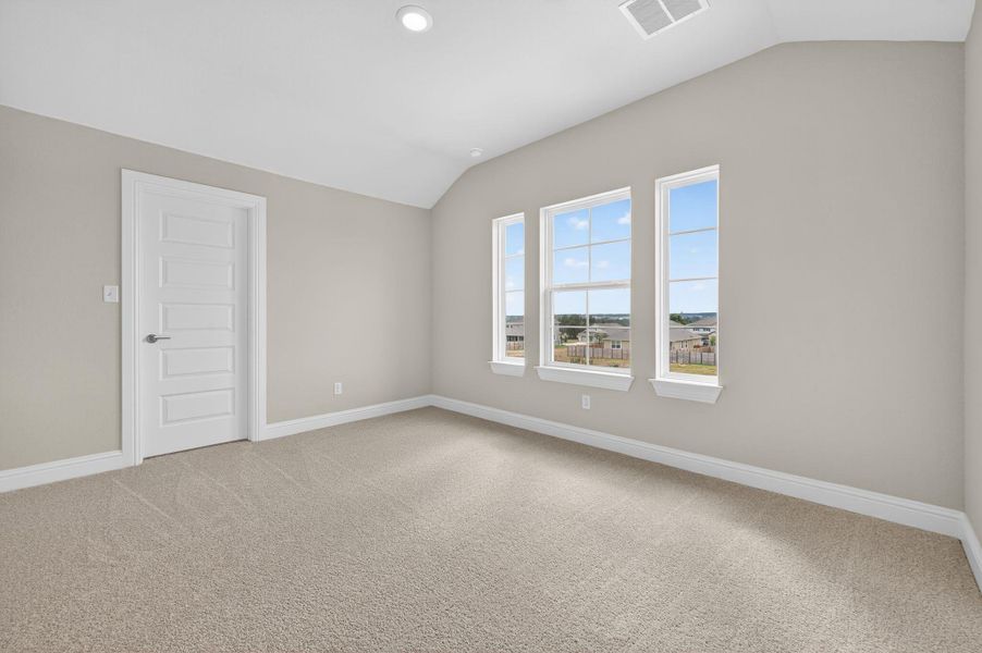 Spare room with lofted ceiling and light colored carpet