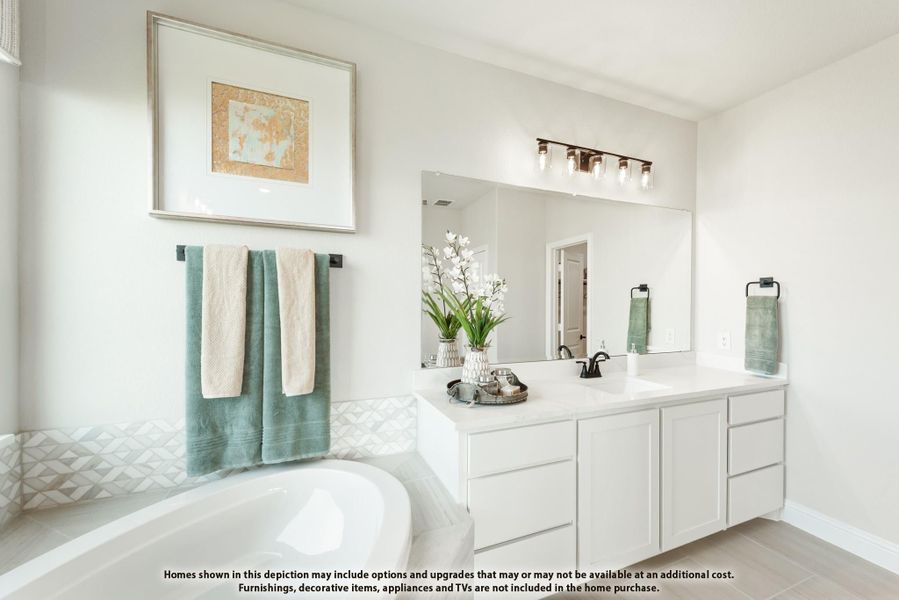 Bathroom with white double vanity, large mirror, soaking tub, and geometric tile accent wall Bathroom with white double vanity, large mirror, soaking tub, and geometric tile accent wall