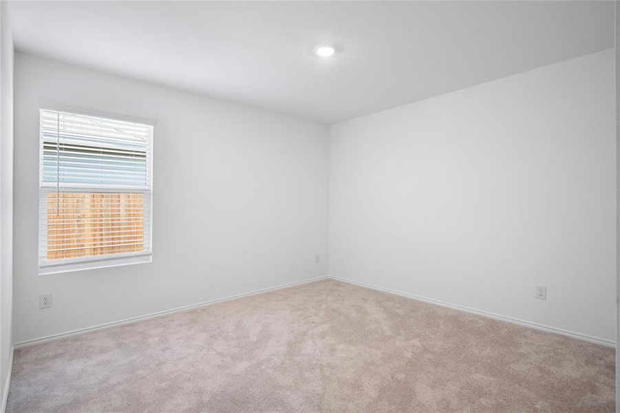 Spacious room with light neutral carpet and white walls Spacious room with light neutral carpet and white walls
