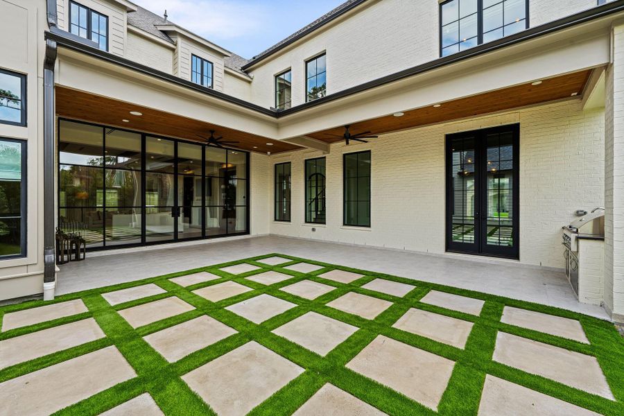Another perspective of the backyard showcasing the clean grid-pattern pavers w/ turfed joints, this angle highlights the seamless connection back to the covered patio & interior living spaces. A well-balanced outdoor setting designed for both functionality & everyday enjoyment. Another perspective of the backyard showcasing the clean grid-pattern pavers w/ turfed joints, this angle highlights the seamless connection back to the covered patio & interior living spaces. A well-balanced outdoor setting designed for both functionality & everyday enjoyment.