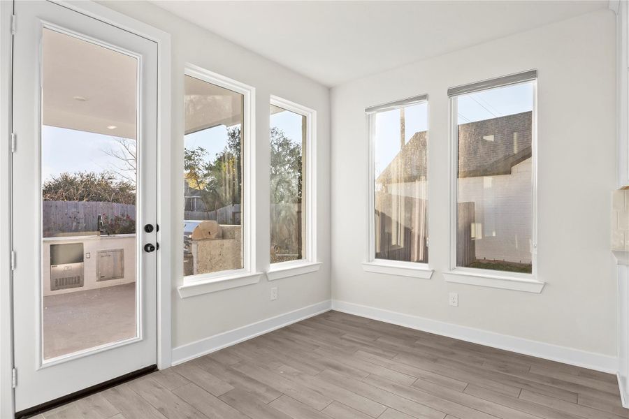 The bright breakfast nook features large windows and French doors, offering abundant natural light and a view of the outdoor area, which includes a built-in grill and a fenced backyard. Ideal for entertaining and relaxation. The bright breakfast nook features large windows and French doors, offering abundant natural light and a view of the outdoor area, which includes a built-in grill and a fenced backyard. Ideal for entertaining and relaxation.