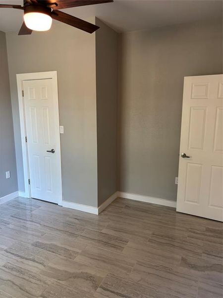 Empty room with wood tiled floors and ceiling fan Empty room with wood tiled floors and ceiling fan