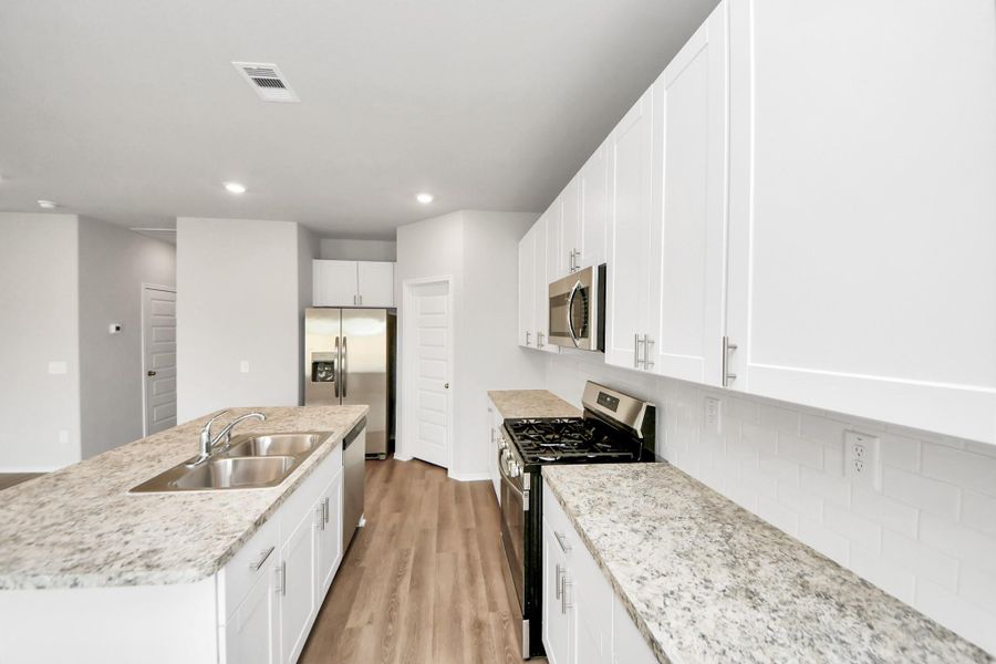White kitchen with handles and brand new stainless steel appliances