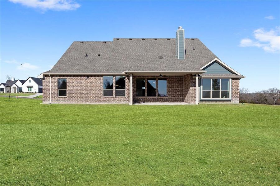 Back of house with a lawn and a patio area