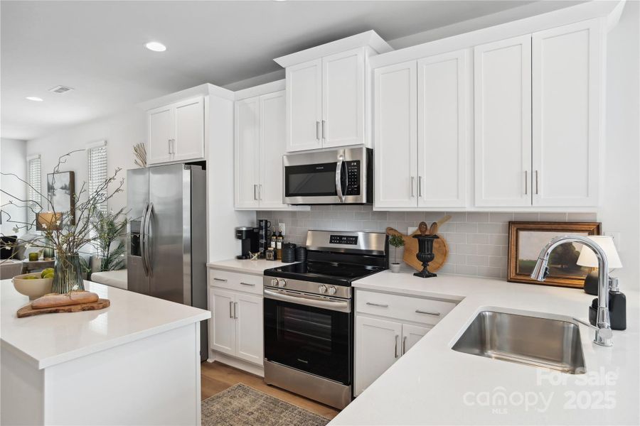 An Abundance of Beautiful, White Kitchen Cabinets and Quartz Couterspace.