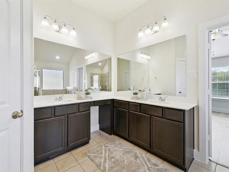 Dual vanity with dark wood cabinetry, white countertops, and integrated sinks