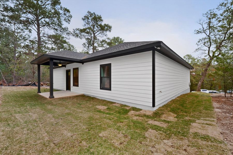 A newly constructed residence features a covered patio, ready for outdoor enjoyment amidst a natural setting. A newly constructed residence features a covered patio, ready for outdoor enjoyment amidst a natural setting.
