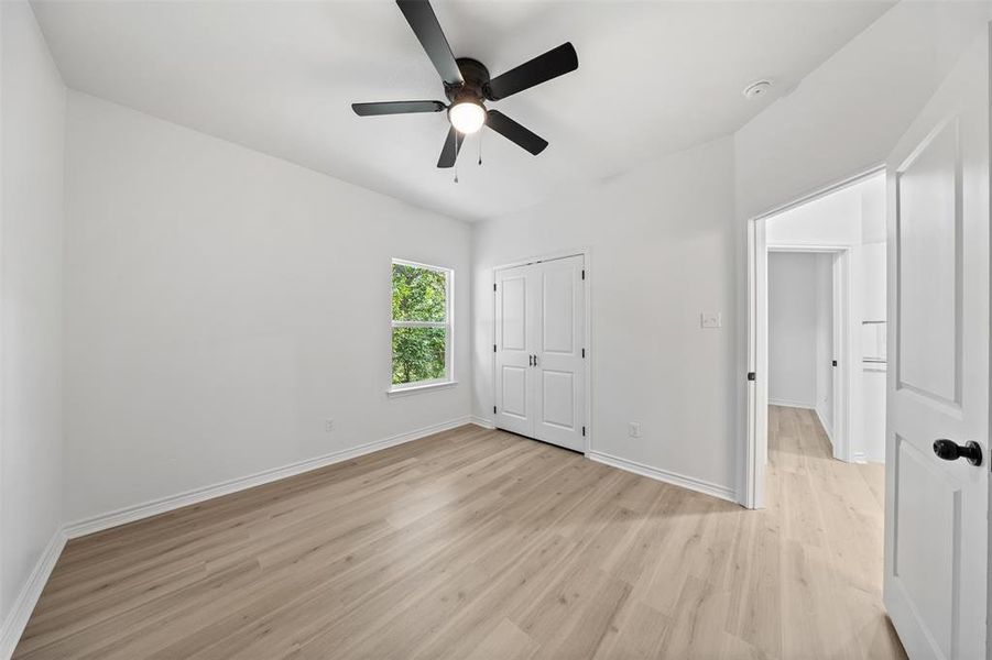 Unfurnished bedroom featuring light wood-style floors, ceiling fan, and a closet