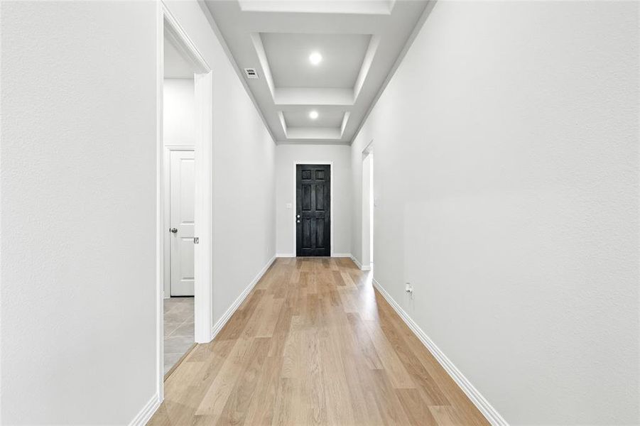 Corridor featuring baseboards and light wood finished floors Corridor featuring baseboards and light wood finished floors